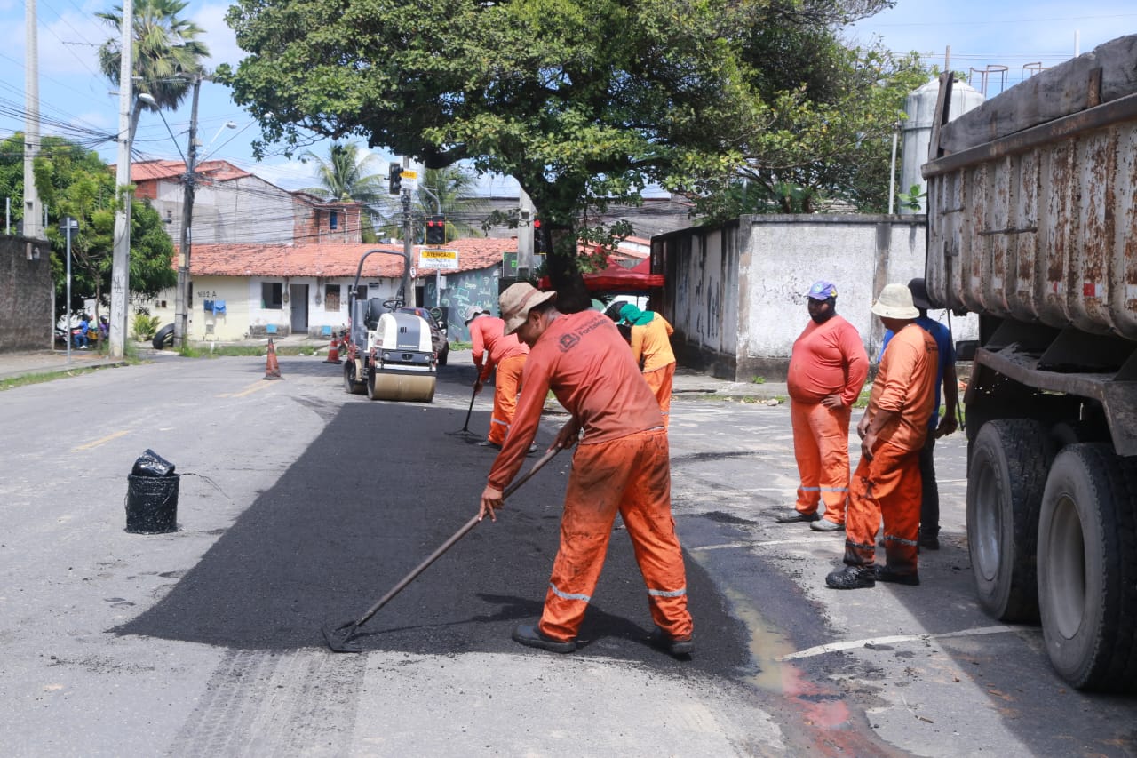 homens asfaltando uma via